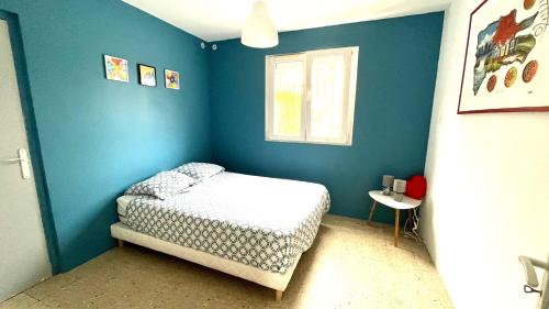 une chambre bleue avec un lit et une fenêtre dans l'établissement Grand appartement, en bord de mer, 8 à 10 personnes, à Saint Pierre La Mer