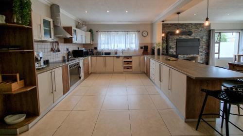 a large kitchen with white cabinets and a large island at At 47 Turmalin Holiday House in Swakopmund