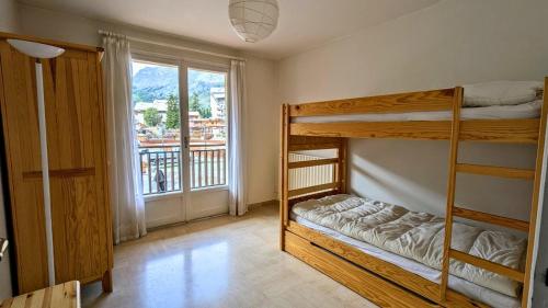une chambre avec deux lits superposés et une fenêtre dans l'établissement Auron centre 2P idéal famille, à Saint-Étienne-de-Tinée