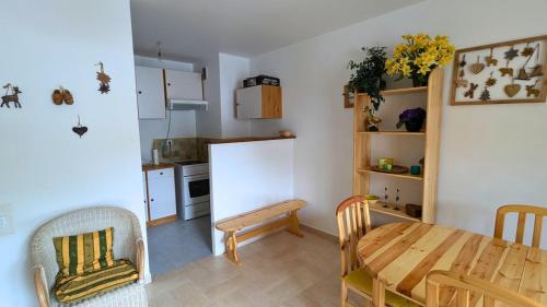 une cuisine avec une table en bois et une salle à manger dans l'établissement Auron centre 2P idéal famille, à Saint-Étienne-de-Tinée