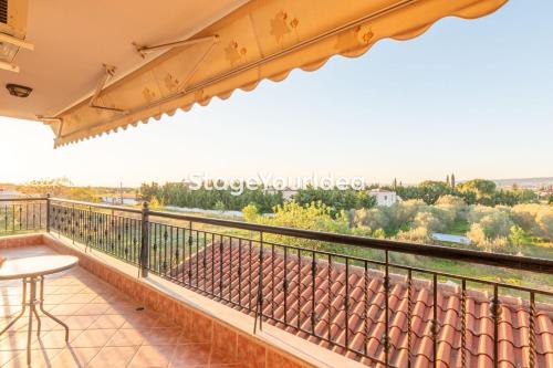 a balcony with a table and a view at Luxury appartment, only 7 minutes from Thessaloniki airport and 15 minutes from city center ,for 8-23 people also for gatherings and parties in Néon Rýsion