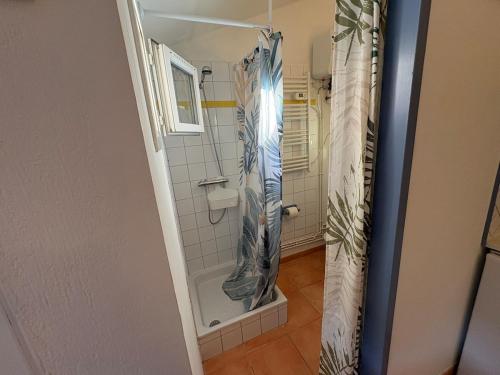 une salle de bain avec une douche avec un rideau de douche dans l'établissement 4 personnes - terrasse- proche plage, à Torreilles