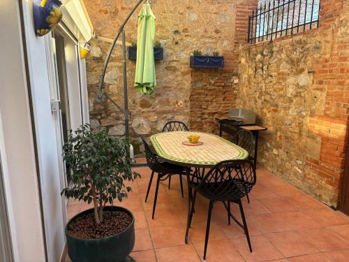 une terrasse avec une table, des chaises et une plante dans l'établissement 4 personnes - terrasse- proche plage, à Torreilles