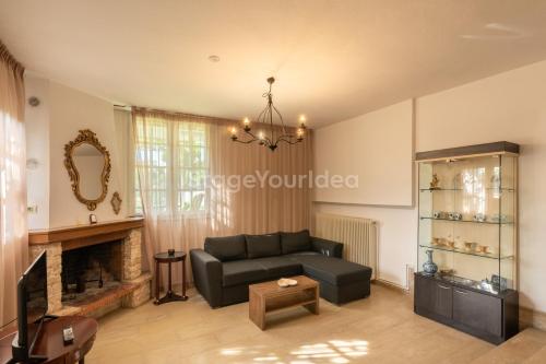 a living room with a couch and a fireplace at Traditional villa appartment with garden, also for gatherings ,15 minutes from Thessaloniki airport in Thessaloniki