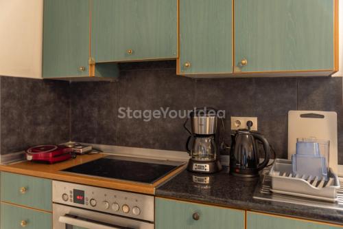 a kitchen with green cabinets and a counter top at Traditional villa appartment with garden, also for gatherings ,15 minutes from Thessaloniki airport in Thessaloniki