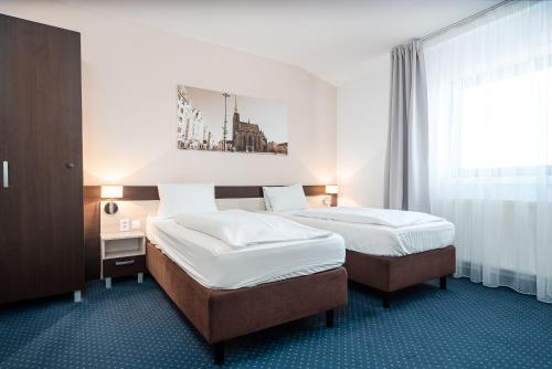 a hotel room with two beds and a window at Wellness penzion U GIGANTU in Plzeň