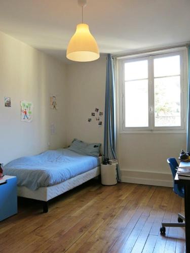 une chambre avec un lit et une grande fenêtre dans l'établissement Charme Vaugirard Procession CityCosy, à Paris