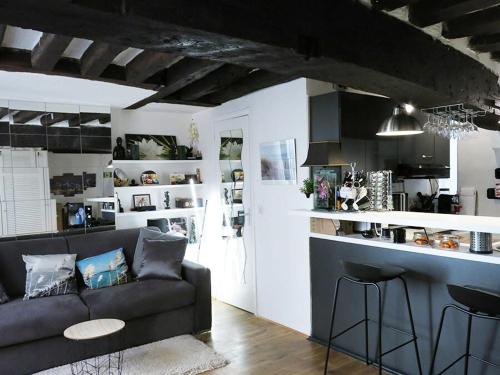 un salon avec un canapé et une cuisine dans l'établissement Studio Marais Charlot CityCosy, à Paris