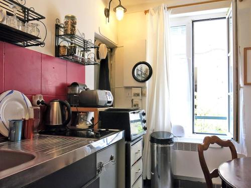 Il comprend une cuisine équipée d'une cuisinière et d'un évier. dans l'établissement Montmartre Del Sarte Cosy CityCosy, à Paris