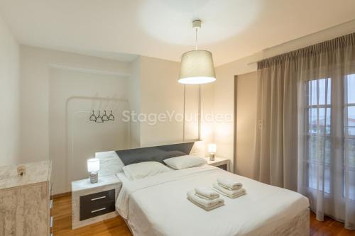 a white bedroom with a bed and a window at Τraditional fully detached villa on a luxurious hillock of Thessaloniki with its own garden also for family & wedding gatherings for 10 to 25 people only 15 minutes from airport in Thessaloniki