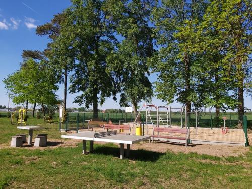 a park with a playground with benches and swings at Pensjonat Zielone Podlasie in Ruda