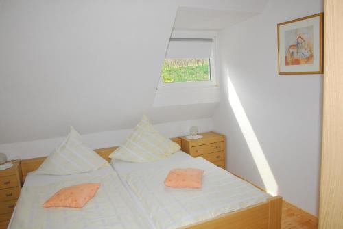 a bedroom with a bed with two pillows and a window at Ferienwohnung Auf Mullay in Reil