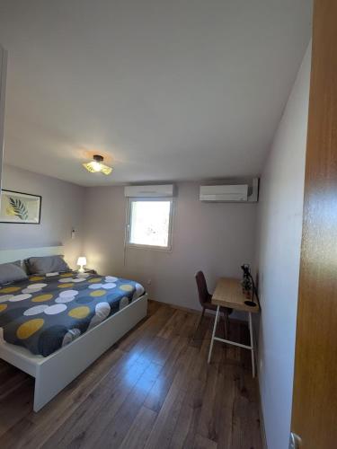 une chambre avec un lit, un bureau et une table dans l'établissement Duplex le Lardenne - proche Hôpital - Clim - Terrasse - Parking, à Toulouse