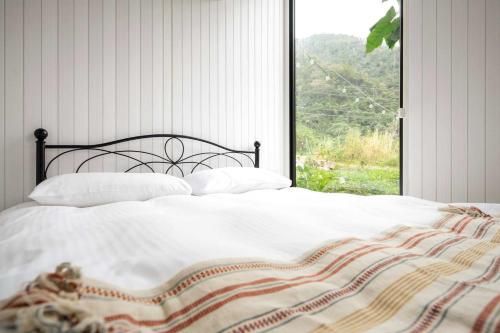 a bed in a bedroom with a large window at Lanka 1 by Tiny Away in Ti-li