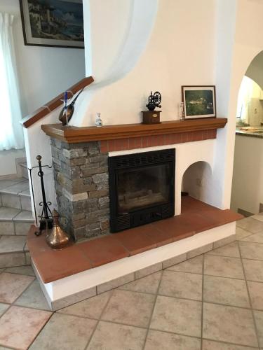 einen Kamin im Wohnzimmer mit einer Treppe in der Unterkunft Appartamento Romantico in Gambarogno