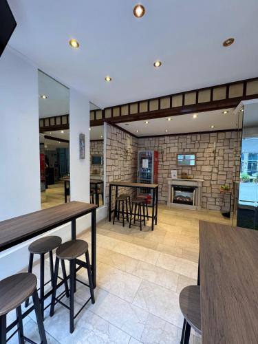 a dining room with tables and chairs and a fireplace at Centro Hotel Mondial München City, Trademark Collection by Wyndham in Munich