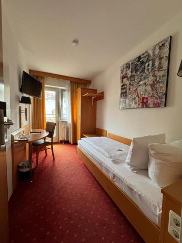 a hotel room with a bed and a desk at Centro Hotel Mondial München City, Trademark Collection by Wyndham in Munich