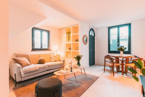 una sala de estar con un sofá y una mesa en Charmante Maisonnette au Prado Carré d'Or by Maison Galante, en Marsella