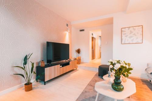 un salon avec une télévision à écran plat sur un mur dans l'établissement Charmante Maisonnette au Prado Carré d'Or by Maison Galante, à Marseille