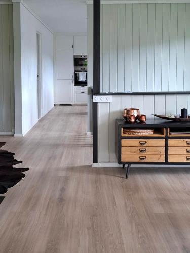 a kitchen with white cabinets and a wood floor at ThePearl in Sel