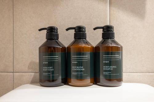 three bottles of liquid sitting on top of a shelf at Aank Hotel Yeongdeungpo in Seoul