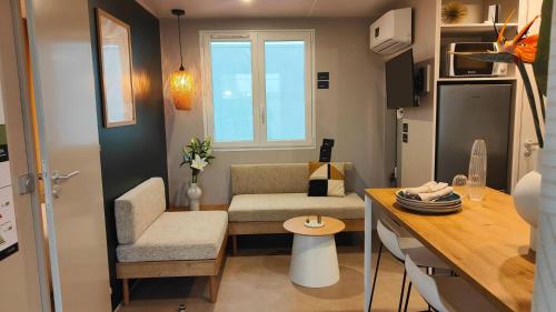 un petit salon avec un canapé et une table dans l'établissement Camping Resort La Baume La Palmeraie, à Fréjus
