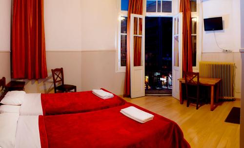 um quarto com uma cama vermelha com duas toalhas em Argo em Tessalônica