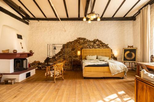 a bedroom with a bed and a stone wall at Gut Neuwerk in Kall