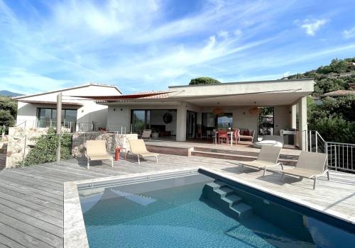 une maison avec une piscine devant une maison dans l'établissement Villa Cazélie, piscine vue splendide sur le Golfe, à Porto-Vecchio