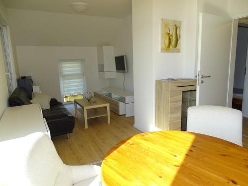 a living room with a wooden table in a living room at Sunny Side Apartments in Postmünster
