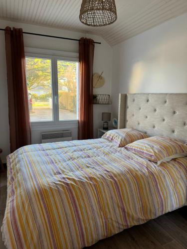 une chambre avec un lit avec une grande fenêtre dans l'établissement Maison sur la plage , pour vivre des vacances iodées 