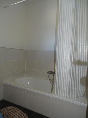 a bath tub in a bathroom with a shower curtain at Sunny Side Apartments in Postmünster