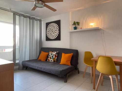 un salon avec un canapé et une table dans l'établissement Studio Grau du Roi 5 min plage, au Grau-du-Roi