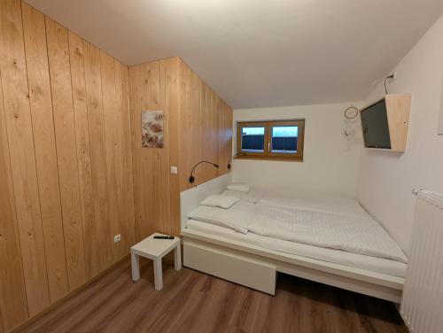 a small bedroom with a bed and a window at Ferienwohnung Goasnstoi - mit HotTub und Bergblick im Inntal in Flintsbach am Inn