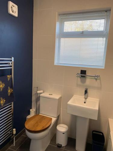 a bathroom with a toilet and a sink and a window at 3 Bed Family House Free Parking in Southend-on-Sea
