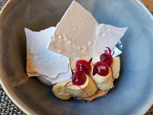 a blue plate with a piece of bread with cheese and cherries at Logis Hôtel Restaurant Relais de la Mothe in Yzeures-sur-Creuse