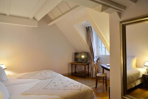 a bedroom with a bed and a mirror and a desk at Logis Hôtel Restaurant Relais de la Mothe in Yzeures-sur-Creuse