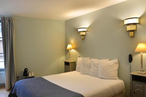 a hotel room with a bed with white pillows at Logis Hôtel Restaurant Relais de la Mothe in Yzeures-sur-Creuse