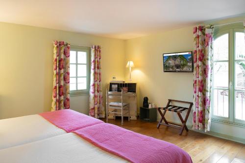 a bedroom with a bed with a pink blanket at Logis Hôtel Restaurant Relais de la Mothe in Yzeures-sur-Creuse