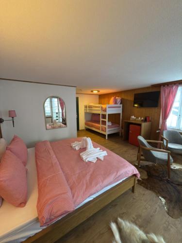 a bedroom with a large bed with pink sheets at Hotel Schützen Lauterbrunnen in Lauterbrunnen
