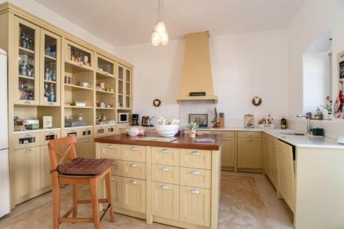 a large kitchen with wooden cabinets and a wooden chair at Piperi On The Rocks in Naousa