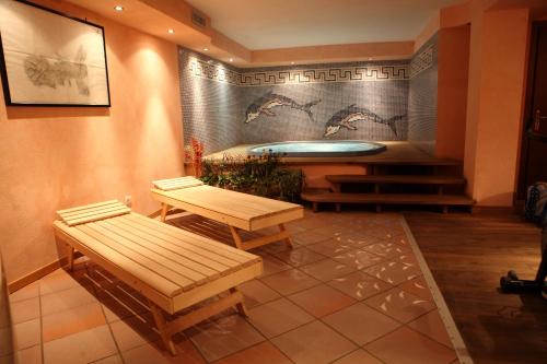 a room with a tub with benches and a table at Hotel Valverde in Gressoney-la-Trinité