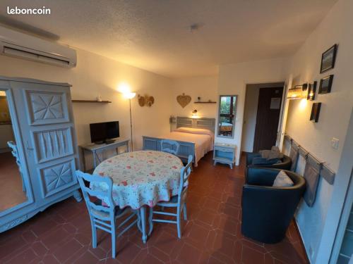 une chambre avec un lit, une table et des chaises dans l'établissement studio Greoux les bains Parc Paradis, à Gréoux-les-Bains