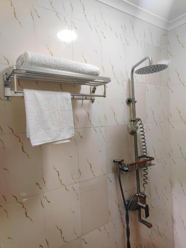 a shower in a bathroom with a white wall at River House Lodge in Arusha