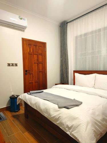 a bedroom with a large bed with a wooden door at River House Lodge in Arusha