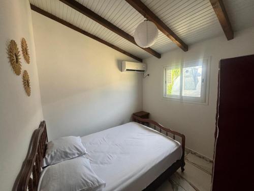 a small bed in a room with a window at Bien venu Miss' K in Anse-Bertrand
