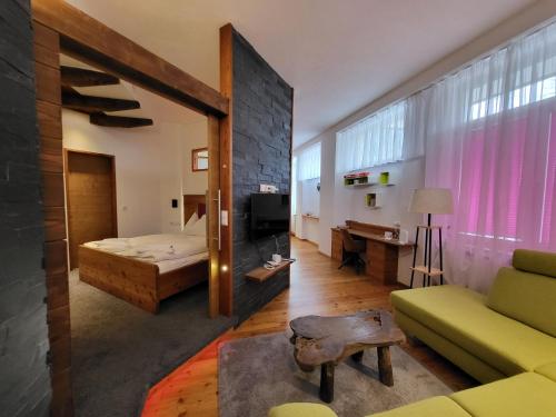 a living room with a couch and a bed at Romantikapartment mit Sommercard in Ramsau am Dachstein
