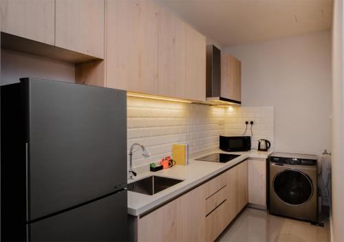 a kitchen with a stainless steel refrigerator and a dishwasher at Iconic Regency Service Residences, managed by Iconic Hotel in Bayan Lepas