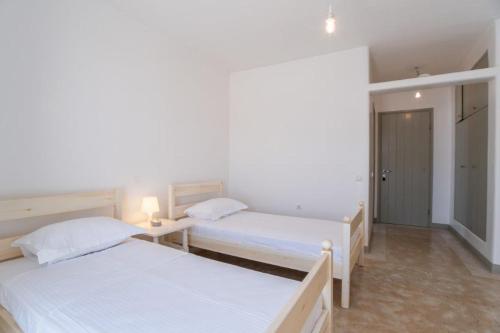 a bedroom with two beds and a hallway at Piperi On The Rocks in Naousa