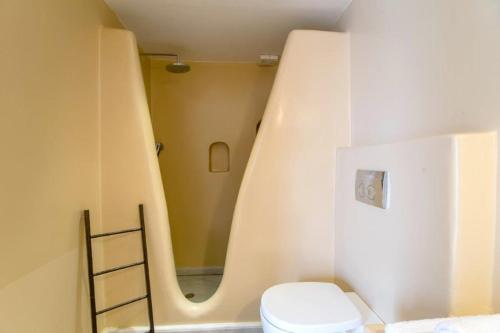 a bathroom with a toilet and a ladder in it at Piperi On The Rocks in Naousa